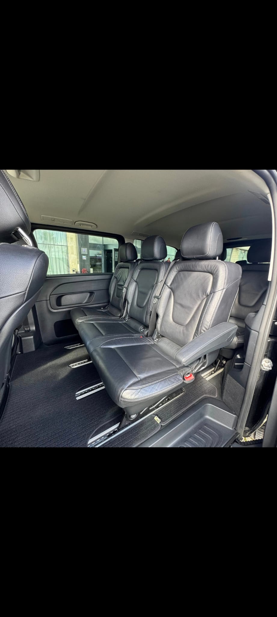 Interior do Mercedes V250 em pele preta, vista para fila traseira.